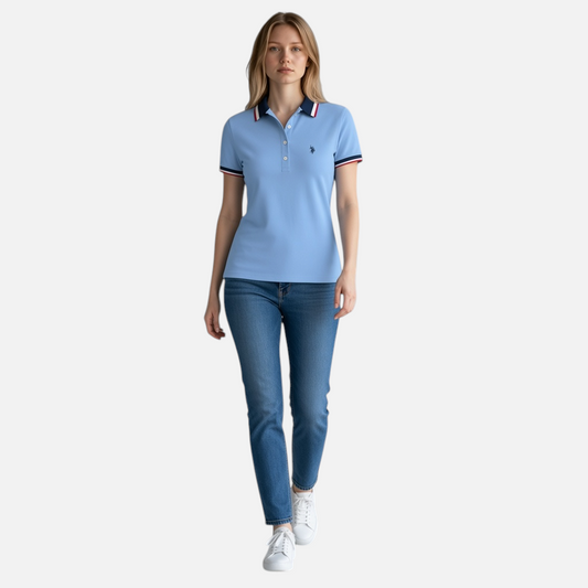 Mujer vistiendo polo azul claro U.S. POLO ASSN. de www.treshop.com.co con detalles en cuello y mangas, corte entallado.
