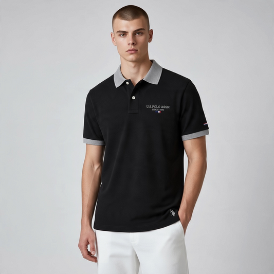 Hombre vistiendo polo negro de www.treshop.com.co con cuello y puños grises texturizados y logo bordado en el pecho