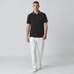 Modelo vistiendo polo negro www.treshop.com.co con cuello estampado y logo bordado, combinado con pantalones blancos.