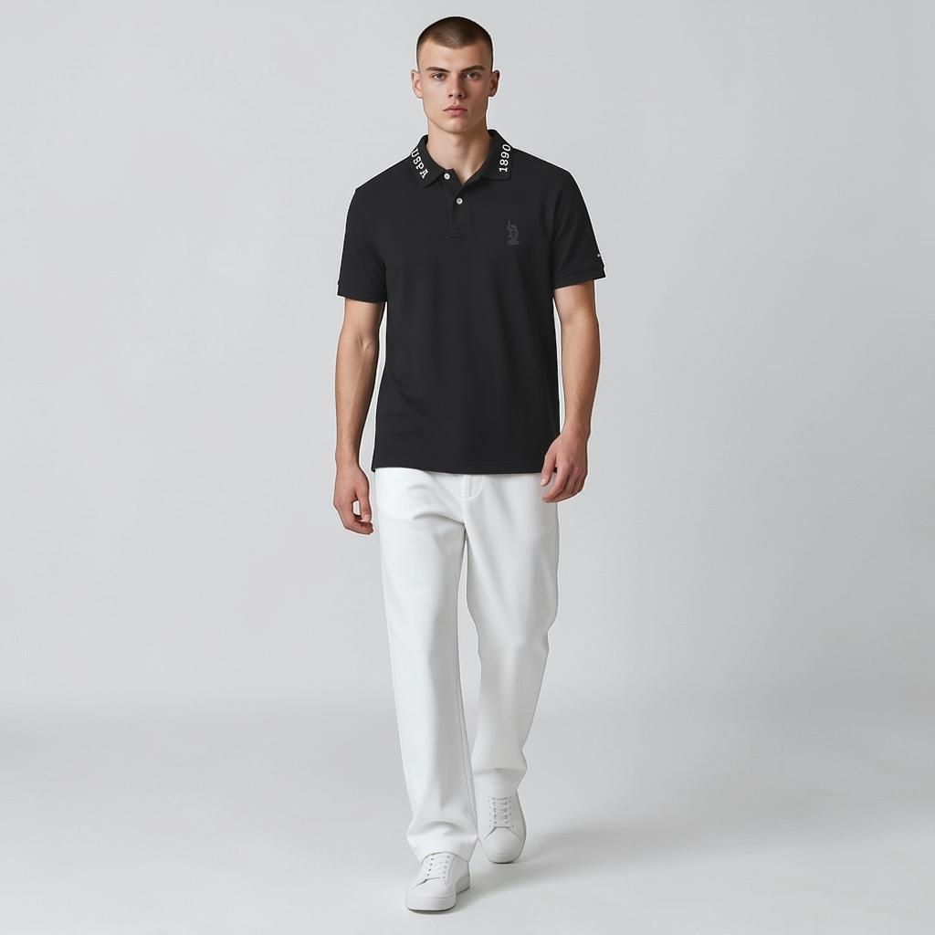 Modelo vistiendo polo negro www.treshop.com.co con cuello estampado y logo bordado, combinado con pantalones blancos.