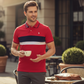 Hombre vistiendo polo rojo con franjas azul y blanco de www.treshop.com.co con logo bordado y cuello detallado