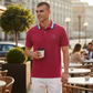 Hombre vistiendo polo rojo www.treshop.com.co con cuello de rayas y logo bordado en una terraza urbana