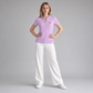 Modelo vistiendo polo rosa de www.treshop.com.co con cuello en V y bordado, combinado con pantalones blancos anchos.