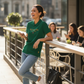 Mujer sonriente vistiendo polo verde de www.treshop.com.co con logo bordado, combinada con jeans y zapatillas