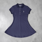 Vestido tipo polo azul marino de www.treshop.com.co con cuello clásico, botones y logo bordado en punto transpirable