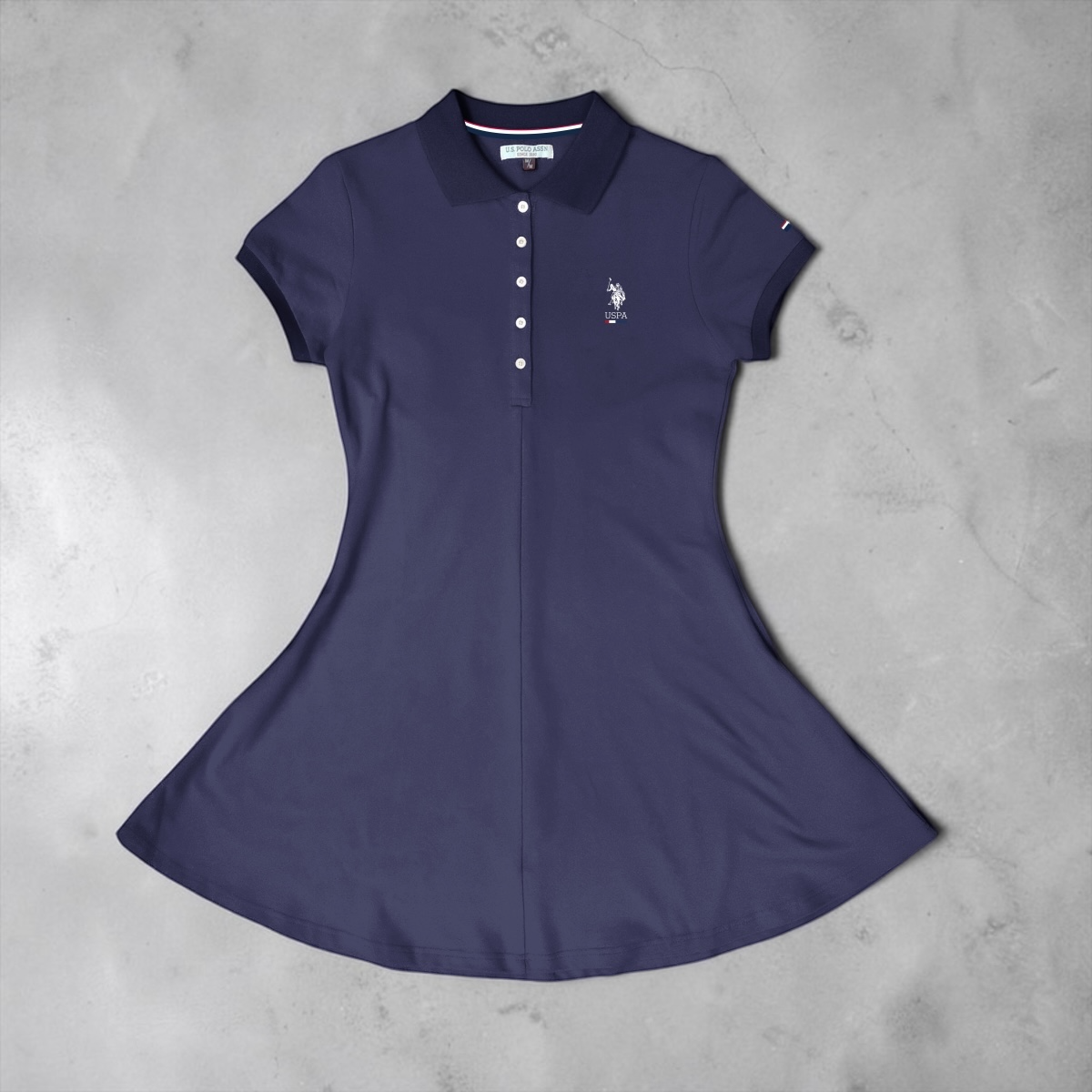 Vestido tipo polo azul marino de www.treshop.com.co con cuello clásico, botones y logo bordado en punto transpirable