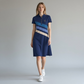 Modelo vistiendo vestido tipo polo azul con franjas diagonales de www.treshop.com.co, cuello clásico y logo bordado.
